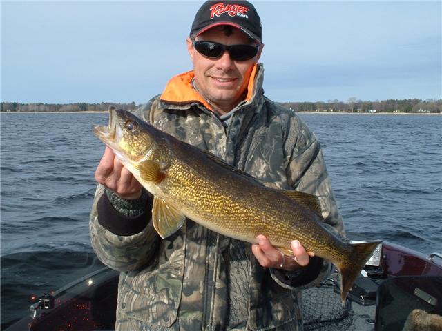 a man holding up a walleye