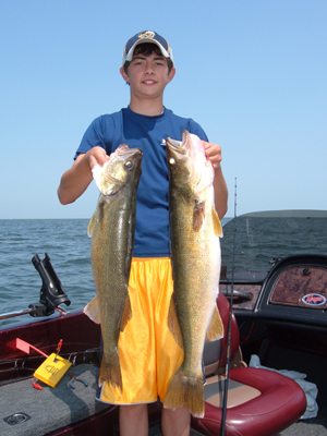 a boy holding up 2 walleyes