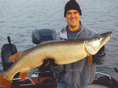 a man holding up a large muskie