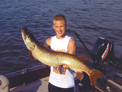 a boy holding up a large muskie