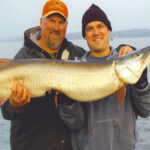 Two men holding a large muskie