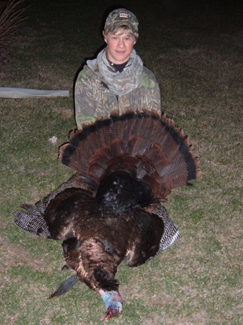 a man holding up a turkey and fanning it's tail out